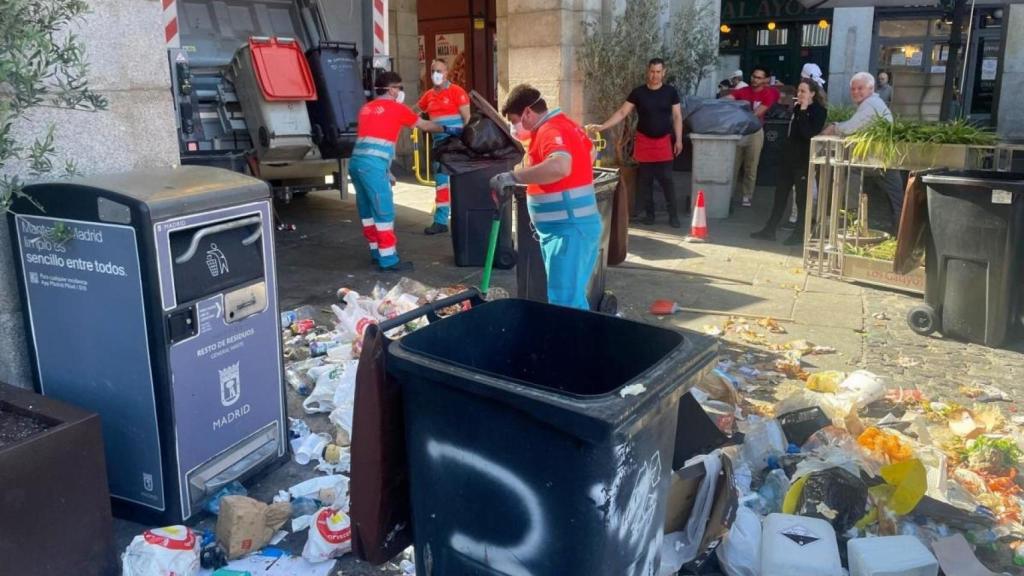 Operarios de limpieza recogen residuos en la Plaza Mayor durante la huelga de basuras de Madrid.