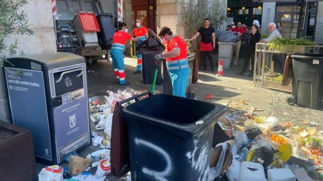 Operarios de limpieza recogen residuos en la Plaza Mayor durante la huelga de basuras de Madrid.