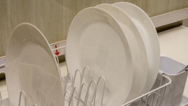 Platos blancos colocados en un escurreplatos.