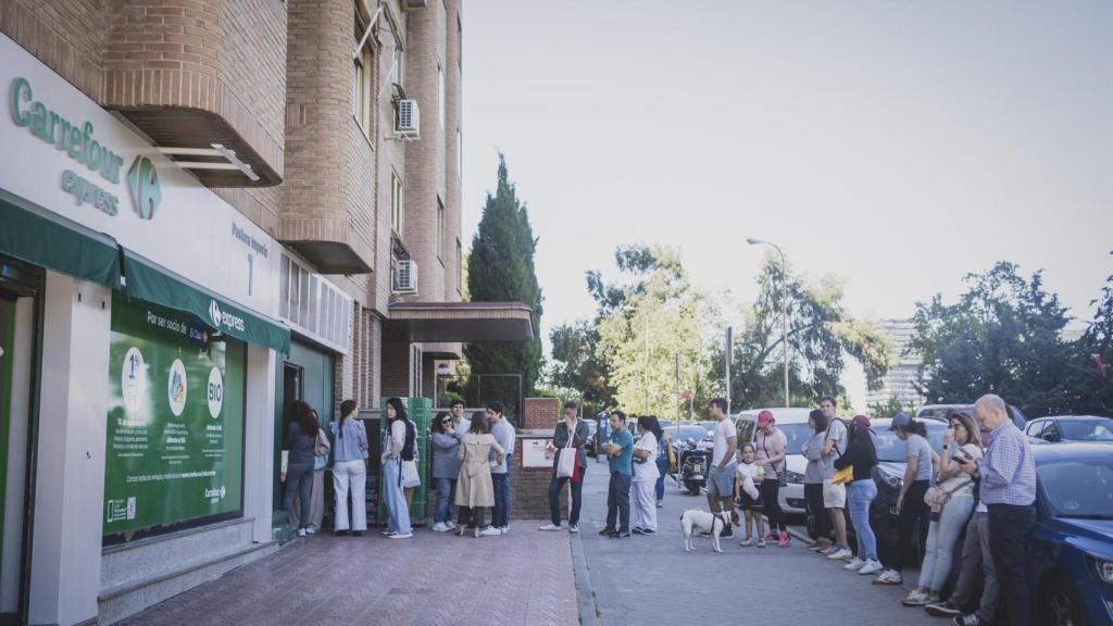Un grupo de personas hace fila en un supermercado después del gran apagón.