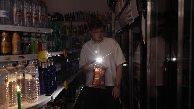 Una persona utiliza su teléfono móvil como linterna en un ultramarinos en Valencia, este lunes, con motivo del apagón de suministro eléctrico. El apagón eléctrico generalizado ha obligado a los bomberos de la provincia de Valencia a realizar ya más de ochenta servicios por rescates en ascensores, según fuentes de este cuerpo de seguridad. EFE/ Biel Alino