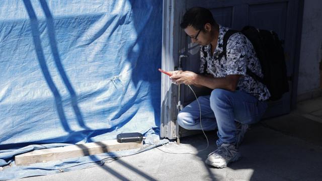 Un hombre carga el móvil con una batería solar en Valencia, este lunes, con motivo del apagón de suministro eléctrico. EFE/Biel Aliño