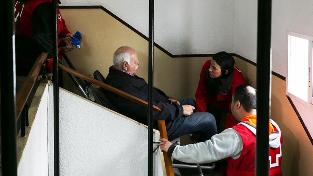 Cruz Roja baja de su casa a un vecino de Alfafar, con movilidad reducida y afectado por la dana, en una silla oruga. Toni Tomás