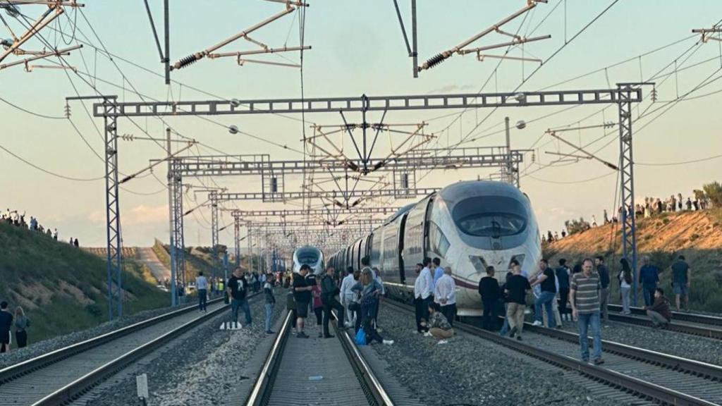 Viajeros de un AVE Madrid - Barcelona esperando en mitad de las vías en pleno campo.