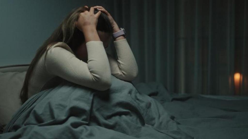 Mujer angustiada en la cama.