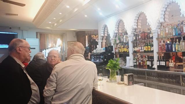 Tres hombres disfrutan de un descanso en la barra del Casino de Torrevieja este martes.