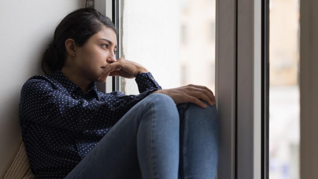 Mujer mirando por la ventana.