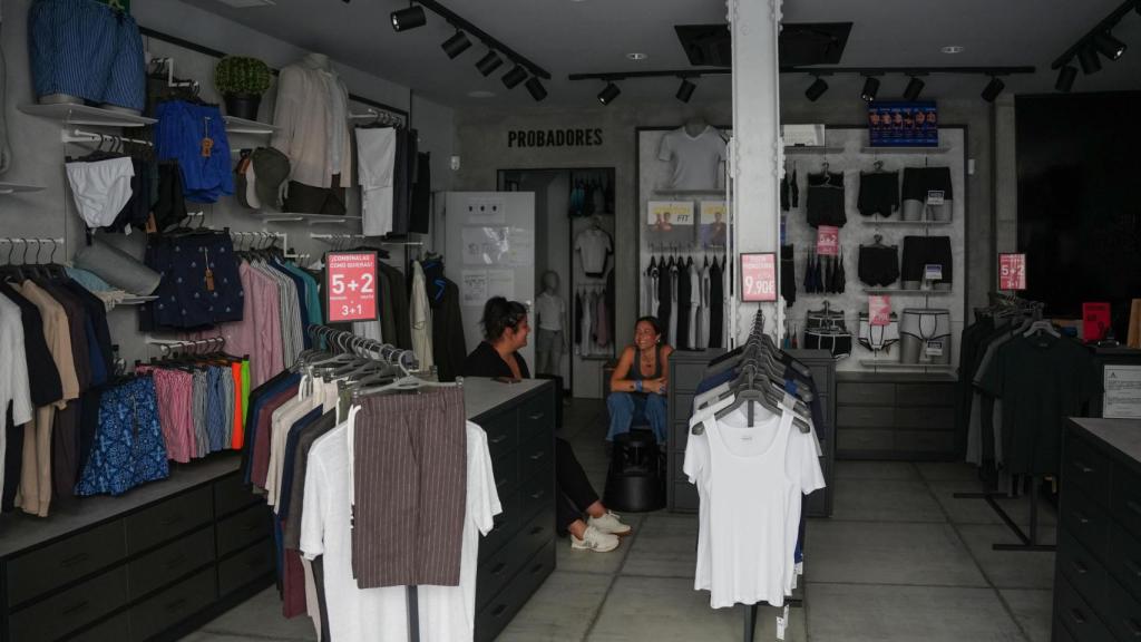 Dos dependientas en un establecimiento sin luz durante el apagón de red eléctrica.