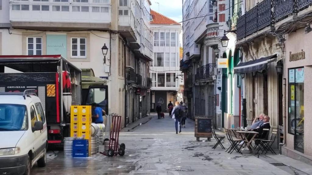Un camión de reparto y los primeros clientes del día en la terraza del café Tortoni este martes.