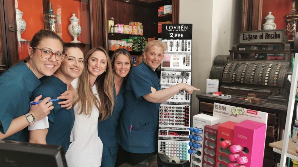 El equipo de Farmacia Mata, junto a la caja registradora que usaron durante el apagón.