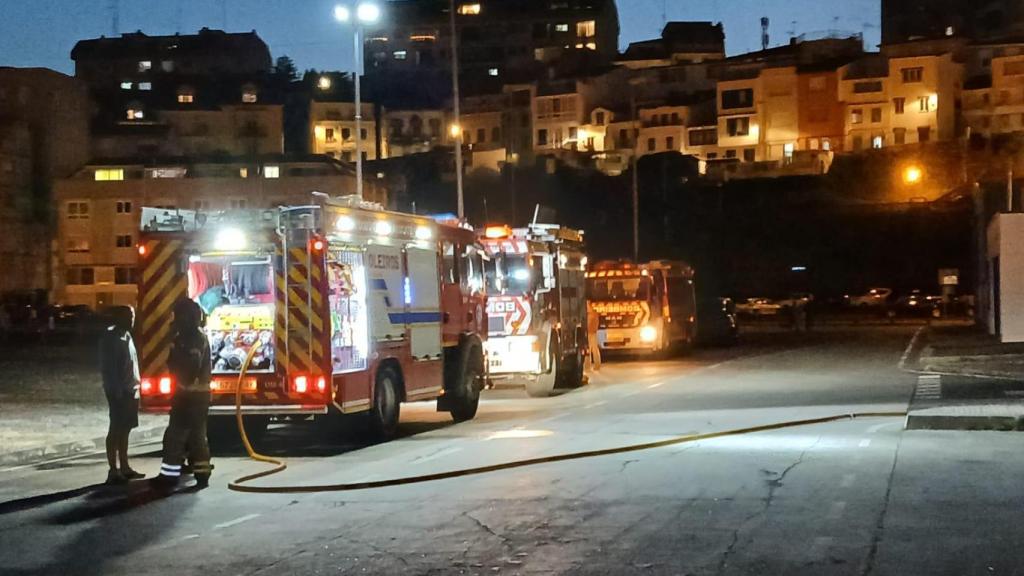 Bomberos trabajando de noche en la extinción del incendio en el puerto de Sara