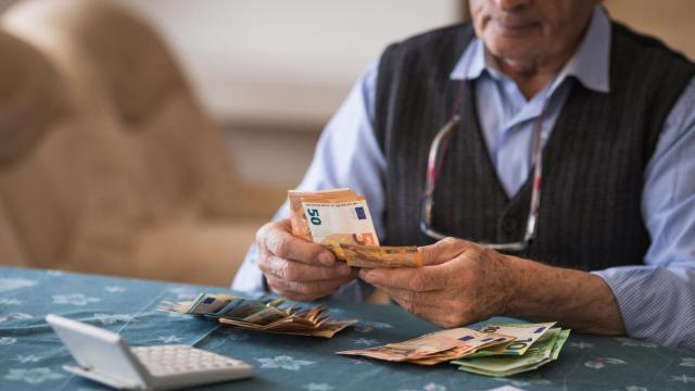 Hombre jubilado contando el dinero en casa.