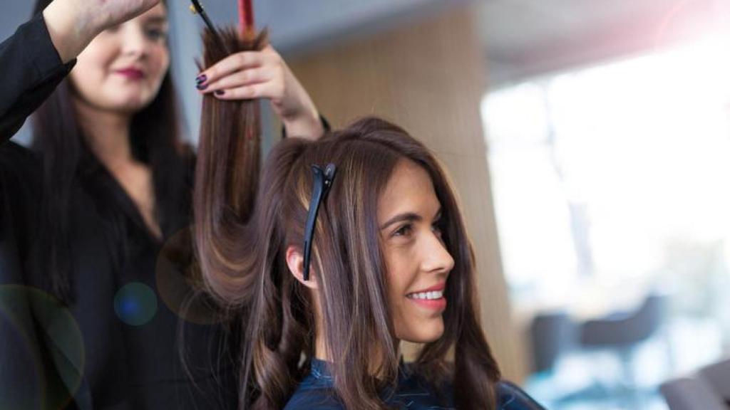 Mujer cortándose el pelo en la peluquería.