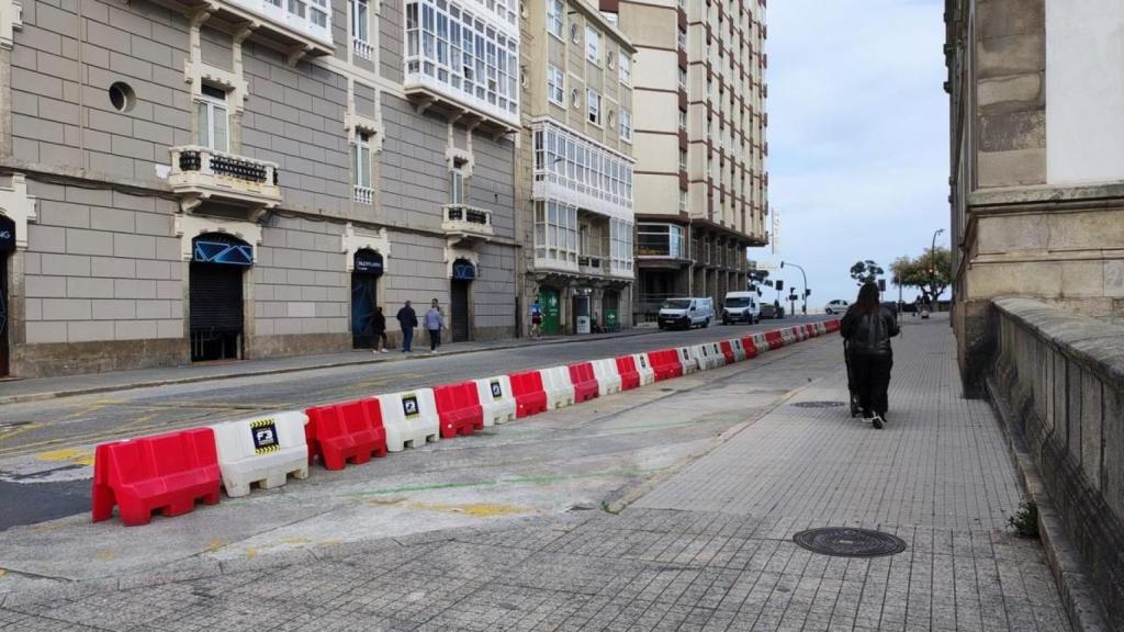 La calle Modesta Goicouría, con el Paseo Marítimo al fondo y con vallas que impiden aparcar en batería.