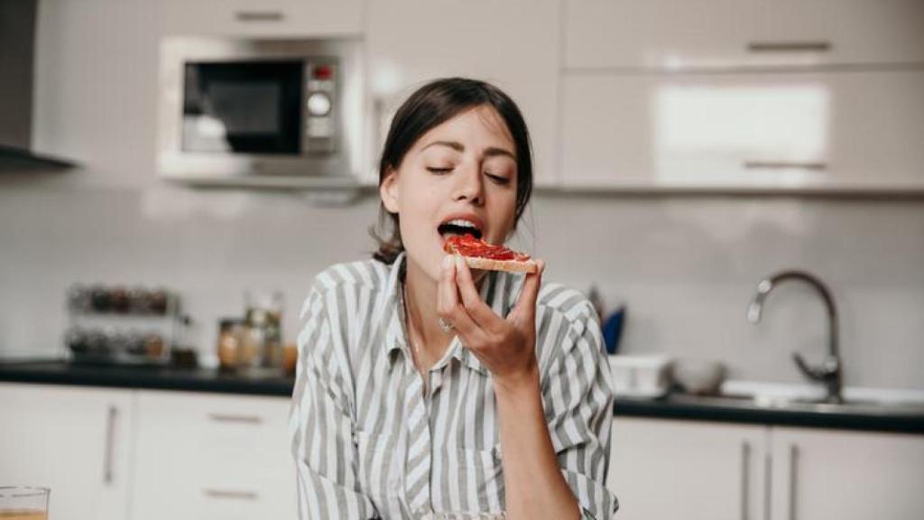 Mujer tomando una tostada.