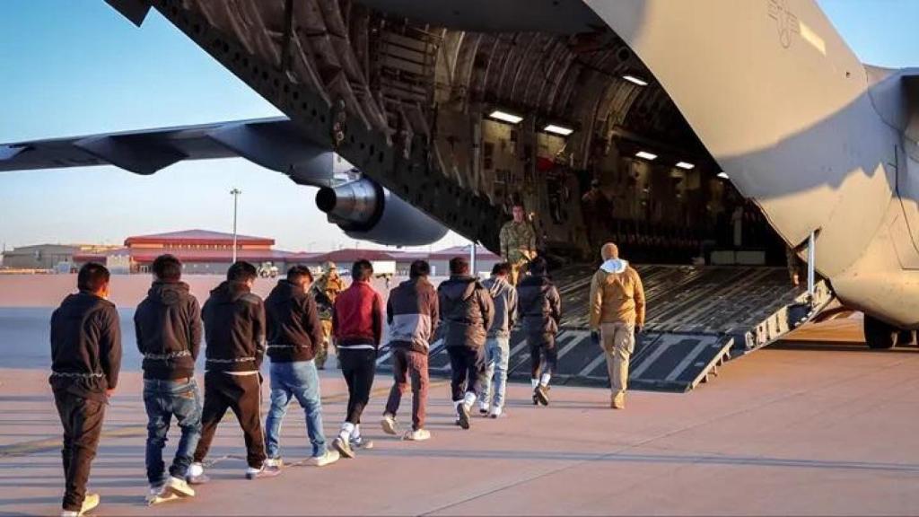 Migrantes suben a un avión militar estadounidense en uno de los vuelos de deportación llevados a cabo por la Administración Trump.