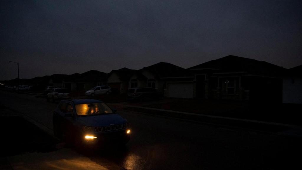 Un coche circula en la oscuridad durante el apagón de Texas de 2021.