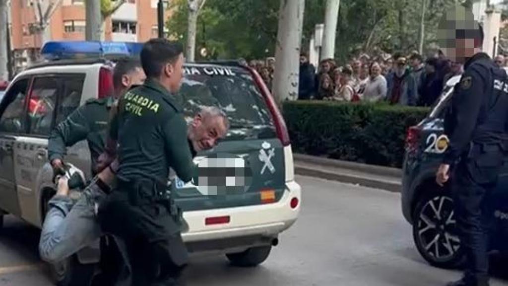 Colin, custodiado por dos guardias civiles, este martes, en la avenida de la Hispanidad de Alcoy, antes de ser introducido a un coche patrulla de la Policía Nacional.