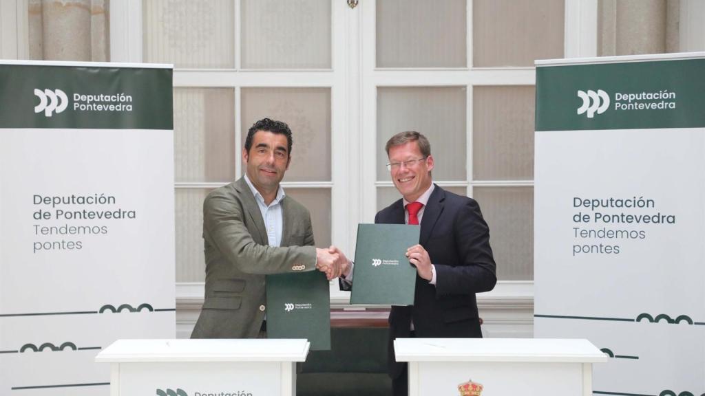 López y Carrera firmando el acuerdo