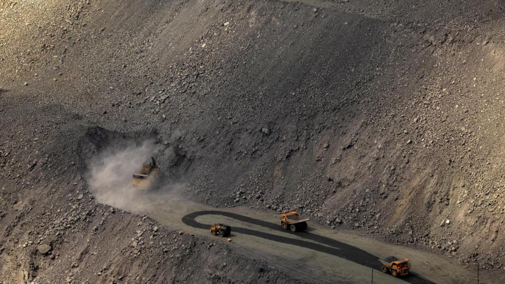 Una excavadora trabaja mientras los camiones mineros avanzan en la mina a cielo abierto Southern Iron Ore JV en Kryvyi Rih, Ucrania.