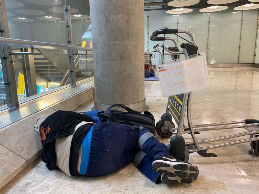 Algunas personas tienen carteles en inglés para pedirle dinero a los turistas del aeropuerto.