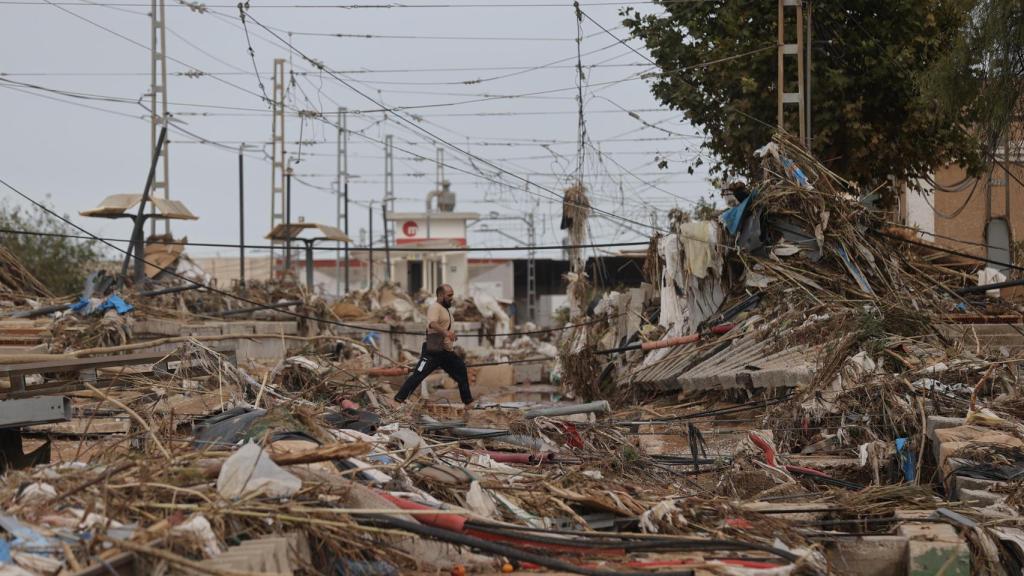 Un hombre pasea por la estación de Paiporta de Metrovalencia, tras quedar arrasada por la dana. Efe / Manuel Bruque