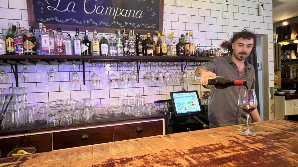 Marcos Castro sirve un copa de vino en La Campana.