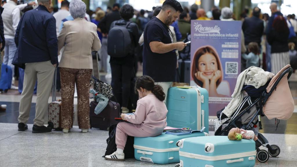 Una familia aguarda en la Estación María Zambrano de Málaga la reanudación del servicio de alta velocidad este lunes tras el robo de cable en cuatro puntos de la provincia de Toledo que ha dejado miles de pasajeros afectados.