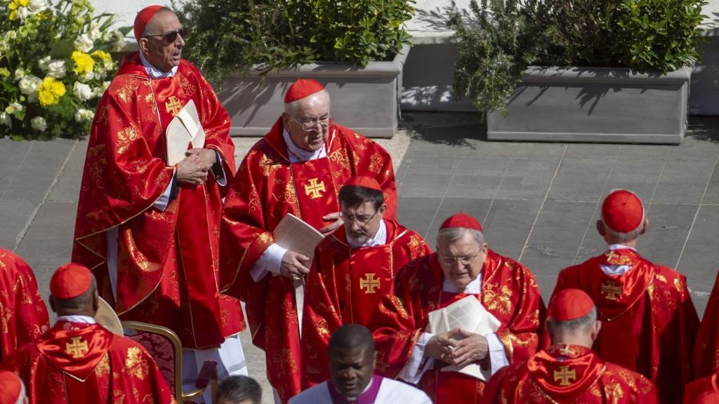José Cobo (c) rodeado de un grupo de cardenales del Colegio Cardenalicio, quienes elegirán al próximo Papa en el Cónclave del 7 de mayo.