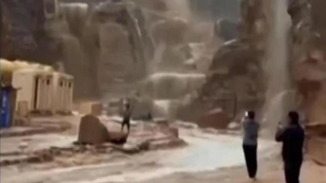 Turistas graban con sus móviles la subida repentina del agua junto al yacimiento de Petra antes de ser evacuados.