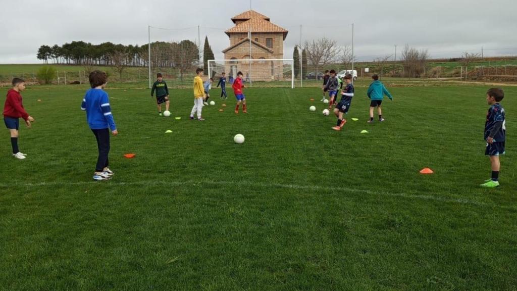 Niños del pueblo jugando en el campo de fútbol.