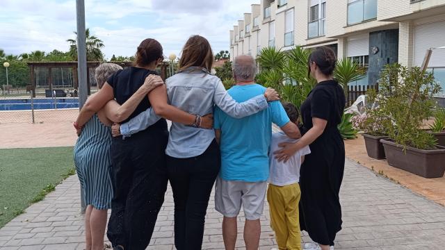 Soledad (i) y Felipe (3d), junto a otros vecinos de la urbanización que iba a ser parcialmente desahuciada este jueves en La Arboleja (Murcia), se reúnen en el patio.