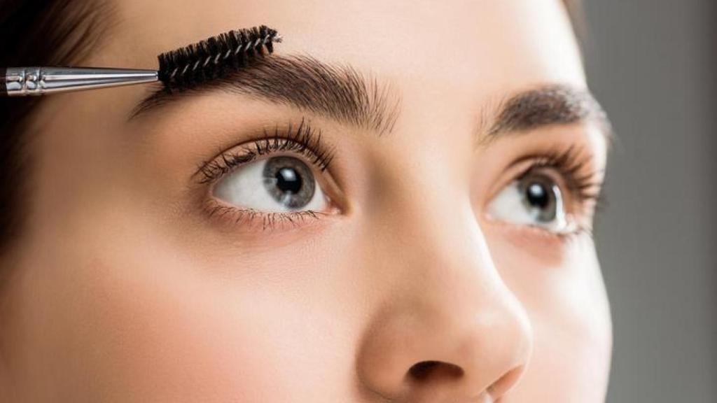 Mujer laminándose las cejas.