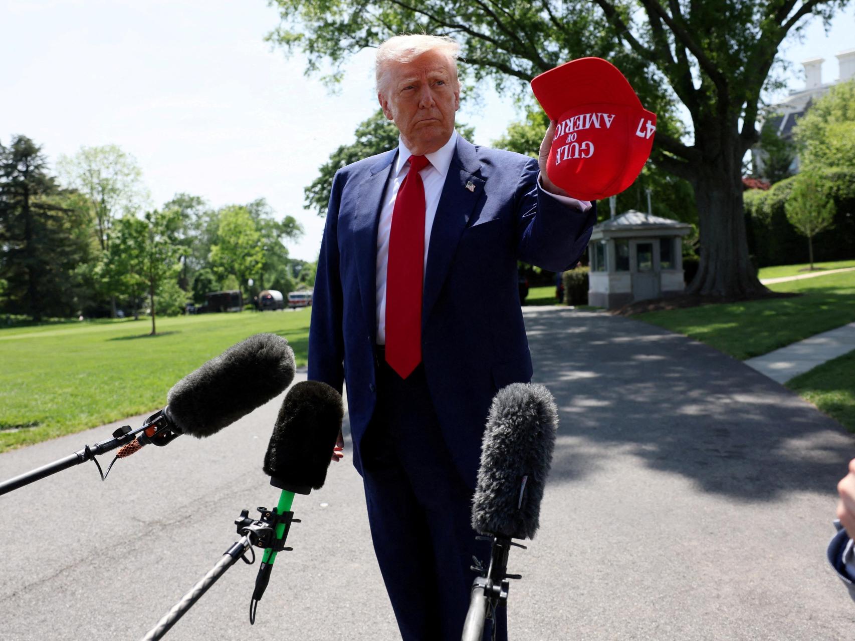 El presidente de Estados Unidos, Donald Trump, sostiene una gorra con las palabras Golfo de América bordadas mientras habla con los medios antes de subir al Marine One para partir hacia Michigan y asistir a un mitin para celebrar sus primeros 100 días en el cargo, desde el Jardín Sur de la Casa Blanca en Washington, D.C., Estados Unidos, 29 de abril de 2025.