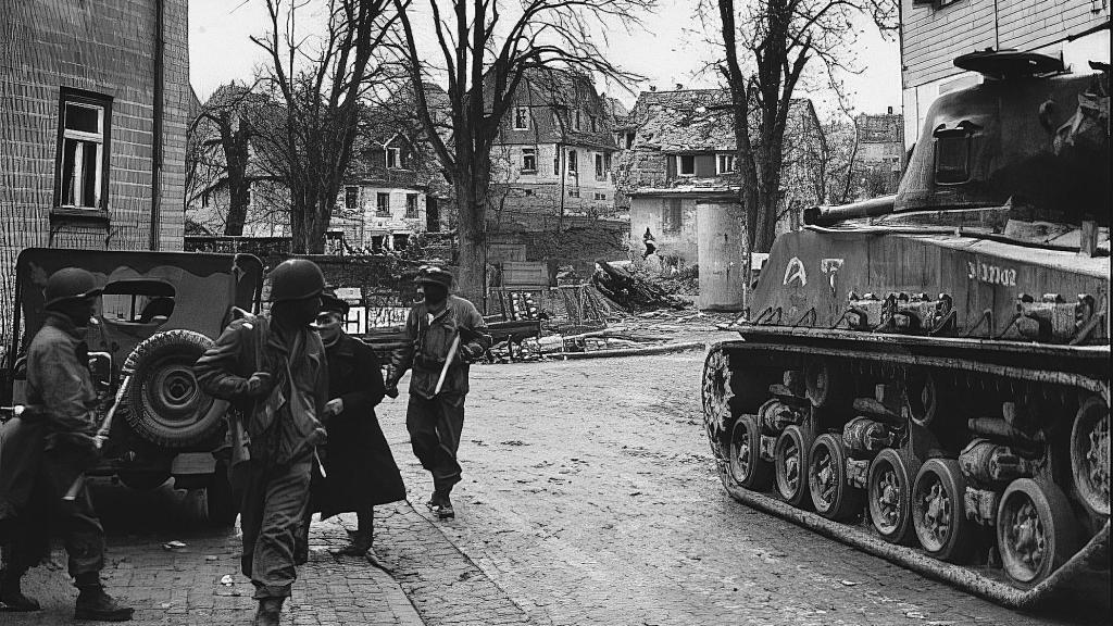 Soldados de a Compañía D del 17.º Batallón de Infantería Acorazada evacúan a civiles alemanes de una ciudad recién capturada.