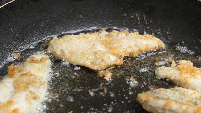 Filetes de pescado friéndose en una sartén.