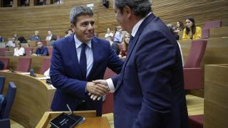 Mazón y el portavoz de Vox, José María Llanos, se dan la mano en un pleno. José Cuéllar / EP