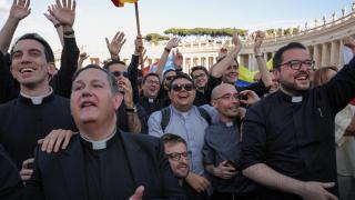 Sacerdotes reaccionan ante el humo blanco que sale de la chimenea de la Capilla Sixtina, indicando que un nuevo Papa ha sido elegido, en el Vaticano, 8 de mayo de 2025.