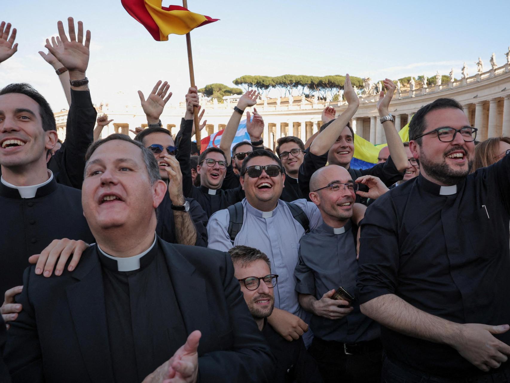 Sacerdotes reaccionan ante el humo blanco que sale de la chimenea de la Capilla Sixtina, indicando que un nuevo Papa ha sido elegido, en el Vaticano, 8 de mayo de 2025.