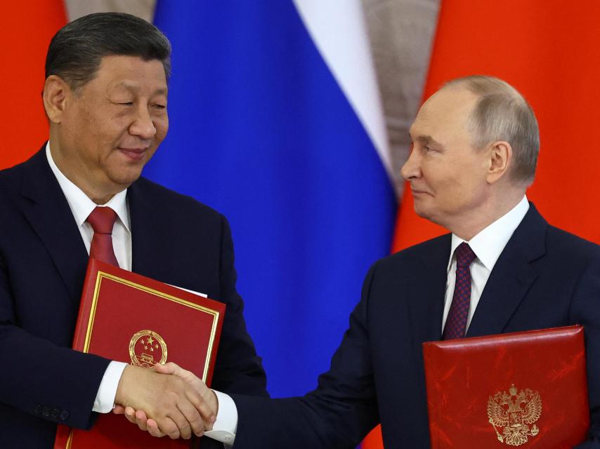 Xi Jinping y Vladimir Putin se dan la mano tras reunirse en Moscú este jueves.