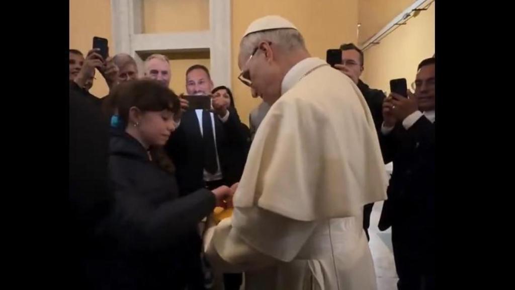 Momento en el que el papa León XIV estampa su firma en la Biblia de una niña.