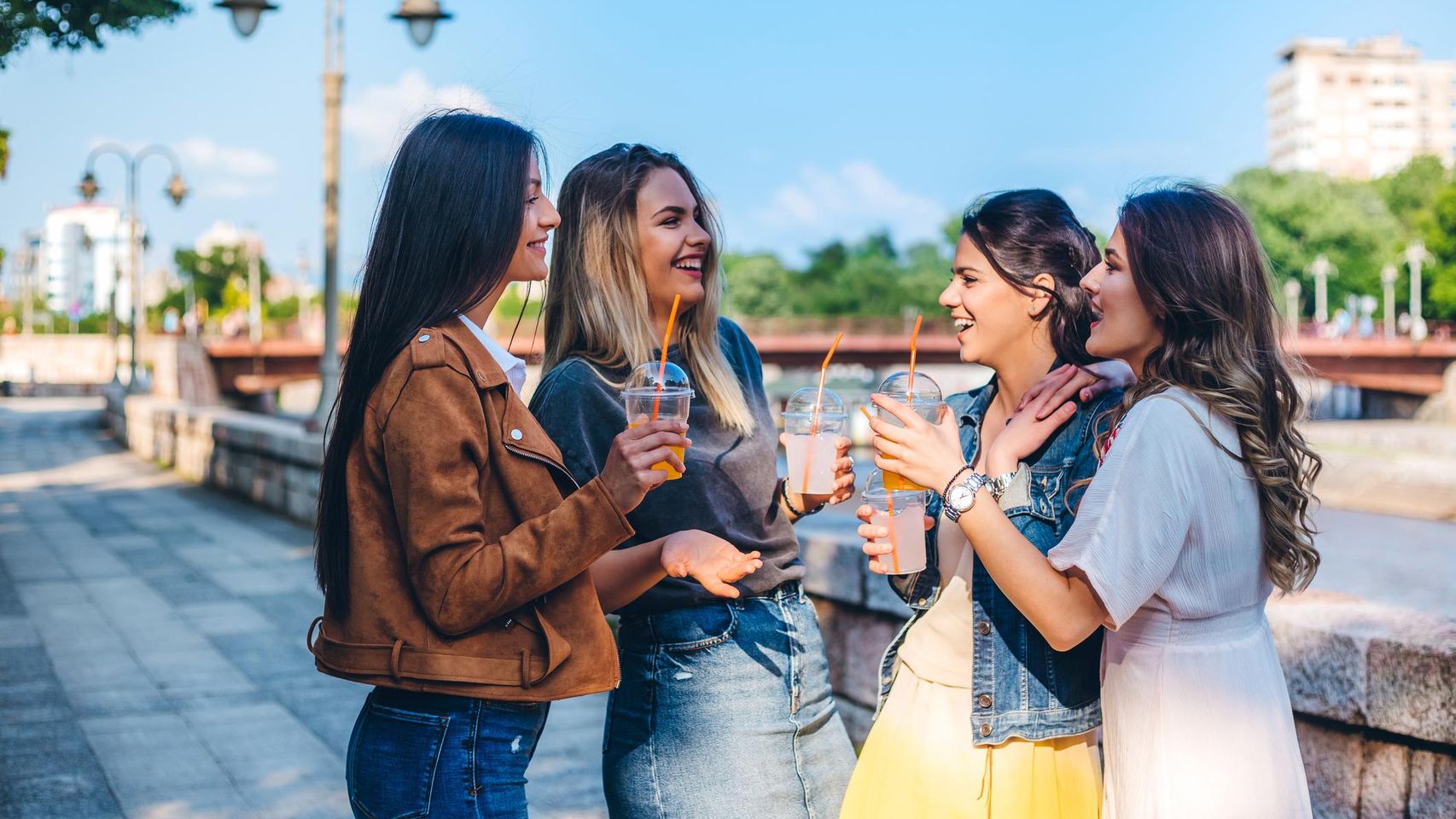 Imagen de un grupo de amigas tomando una limonada en la calle.