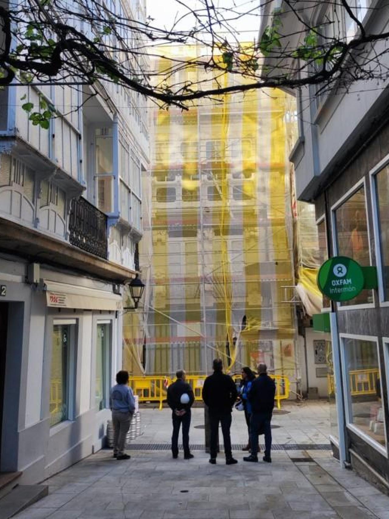 Técnicos y obreros delante de un edificio que se rehabilita en Estrecha de San Andrés.