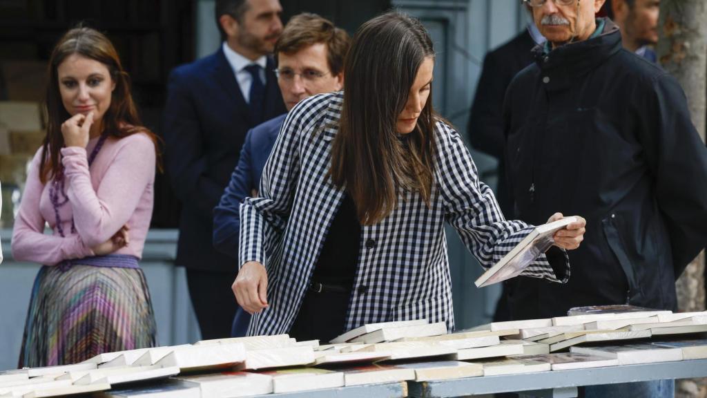 La reina Letizia consulta un libro en la Cuesta de Moyano, feria de libro viejo permanente de Madrid.