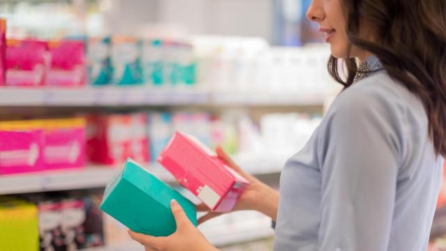Mujer comprando productos de higiene íntima en el supermercado.