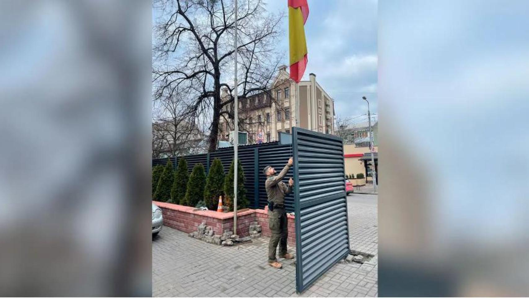 Un agente de los GEO retira la bandera de España de la embajada en Kiev.