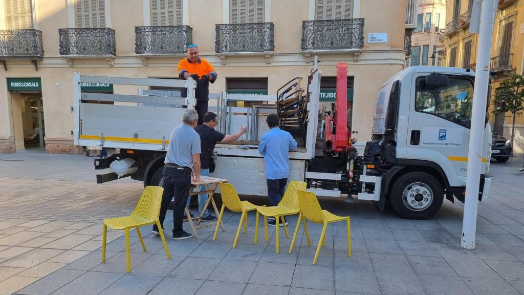 Trabajadores retirando mobiliario urbano.