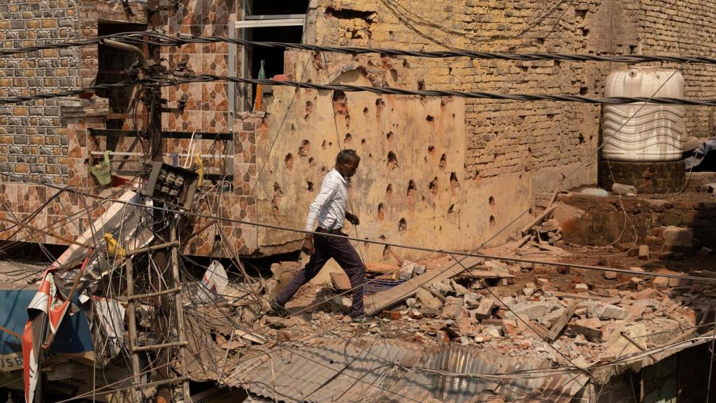 Un hombre camina entre los escombros en el techo de una casa dañada, luego de la operación militar de Pakistán contra India , en Rehari.