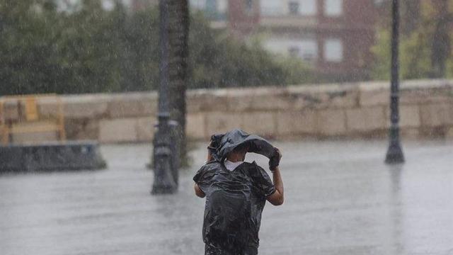 Un hombre cubriéndose de la lluvia, en imagen de archivo.
