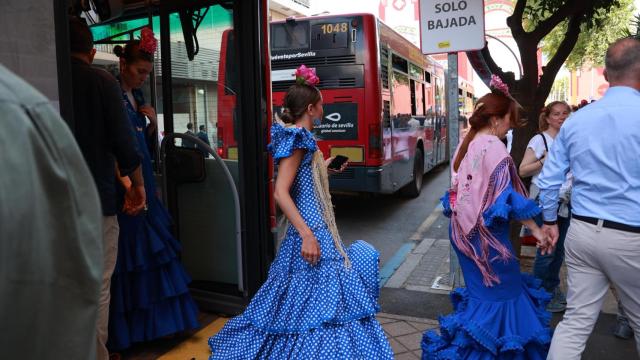 Una mujer se baja de un autobús de Tussam en la Feria.